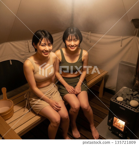 兩名身穿桑拿服的年輕女子在帳篷桑拿房裡出汗 135721809