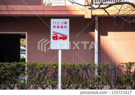 公寓大樓前設有雲梯車停車區域的標誌牌 公寓大樓前設有雲梯車停車區域的標誌牌 135721817