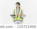 A young Japanese woman wearing work clothes with a safety belt and holding an emergency exit sign on a white background 135721900
