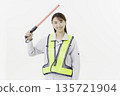 A young Japanese woman wearing work clothes with a safety belt and holding an emergency exit sign on a white background 135721904