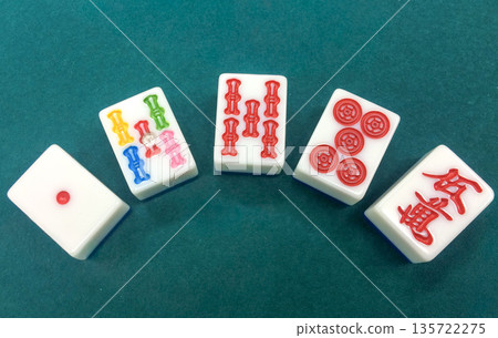 Close-up of mahjong tiles: red dora, red five, and dot tile 135722275