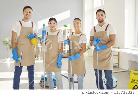 Happy janitors in uniform from professional cleaning service looking at camera. Happy janitors in uniform from professional cleaning service looking at camera. 135722322