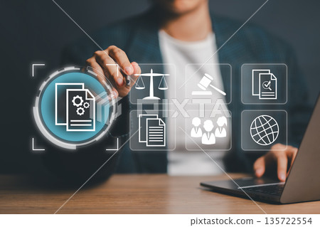 Businessman Interacting with Virtual Interface Displaying Legal and Business Icons on Digital Screen 135722554