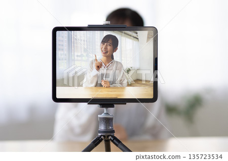 A young woman live streaming using a tablet 135723534