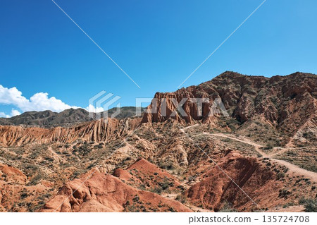Dry Tien Shan mountain landscape in Kyrgyzstan with red earth and blue sky 135724708