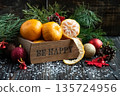 Orange mandarins in wooden box with fir apple, red balls, snowflakes on green fir branch background. Christmas card. Happy new year and merry christmas. High quality photo 135724956