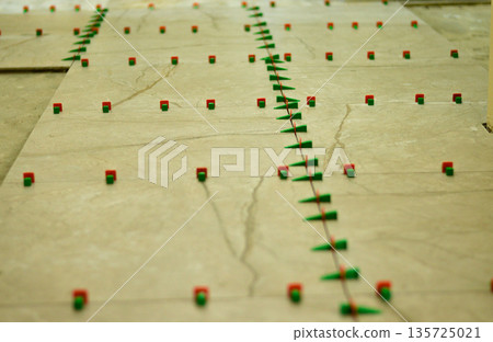 The tile leveling system is a set of special wedges and clamps that allows ceramic tiles to be laid in the same plane without height differences. 135725021