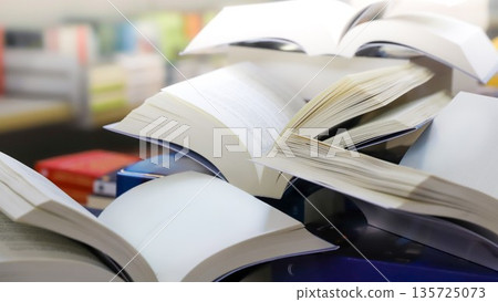 stack of books, close up. Open book on the table in library. Back to school concept. Open book on table with blur bookshelf background 135725073