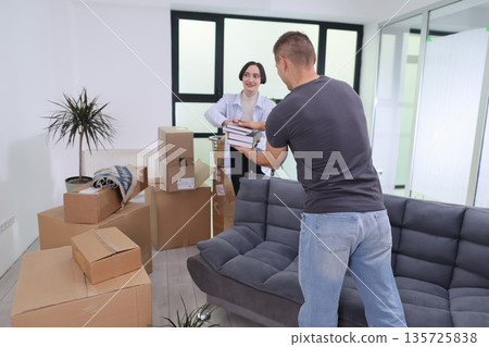 Friends unpacking boxes and setting up a new home in a bright, modern apartment on a sunny afternoon 135725838