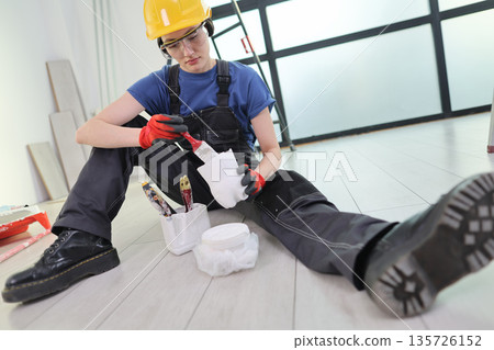 Skilled worker focuses on detail while painting at a modern workspace during daytime renovation Skilled worker focuses on detail while painting at a modern workspace during daytime renovation 135726152