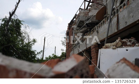 View to destroyed residential buildings at Kharkivska oblast. Ruined houses after bomb attacks on ukrainian territory from russia army. Consequences of russian invasion of Ukraine. Slow motion View to destroyed residential buildings at Kharkivska oblast. Ruined houses after bomb attacks on ukrainian territory from russia army. Consequences of russian invasion of Ukraine. Slow motion 135726329
