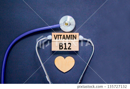 Vitamin B12 symbol. Concept words Vitamin B12 on beautiful wooden blocks. Wooden heart and stethoscope. Beautiful black background. Medical healthy lifestyle Vitamin B12 concept. Vitamin B12 symbol. Concept words Vitamin B12 on beautiful wooden blocks. Wooden heart and stethoscope. Beautiful black background. Medical healthy lifestyle Vitamin B12 concept. 135727132