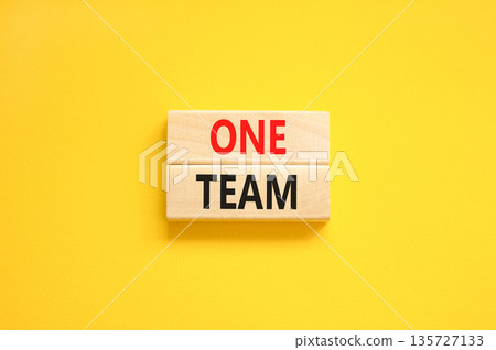 One team symbol. Concept word One team on beautiful wooden blocks. Beautiful yellow paper background. Business one team concept. Copy space. 135727133