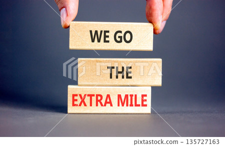 Support, help we go the extra mile symbol. Concept words We go the extra mile on beautiful wooden blocks. Beautiful grey background. Business we go the extra mile concept. Copy space. Support, help we go the extra mile symbol. Concept words We go the extra mile on beautiful wooden blocks. Beautiful grey background. Business we go the extra mile concept. Copy space. 135727163