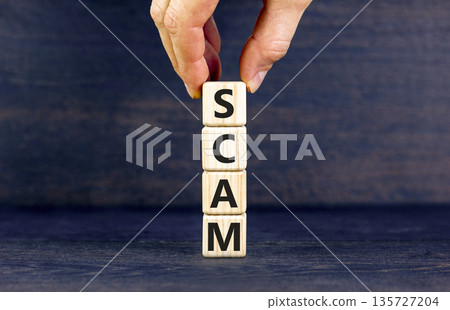 Scam symbol. Concept word Scam on beautiful wooden blocks. Businessman hand. Beautiful black table black background. Business, lifestyle, support and scam concept. Copy space. 135727204