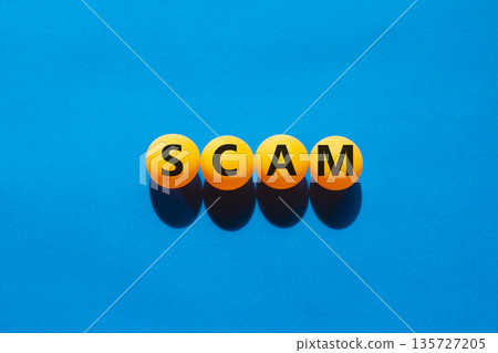 Scam symbol. Concept word Scam on beautiful yellow ping pong balls. Beautiful blue table blue background. Business, lifestyle, support and scam concept. Copy space. Scam symbol. Concept word Scam on beautiful yellow ping pong balls. Beautiful blue table blue background. Business, lifestyle, support and scam concept. Copy space. 135727205
