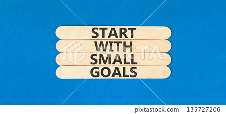 Start with small goals symbol. Concept words phrase Start with small goals on beautiful wooden stick. Beautiful blue paper background. Business Start with small goals concept. Copy space. 135727206