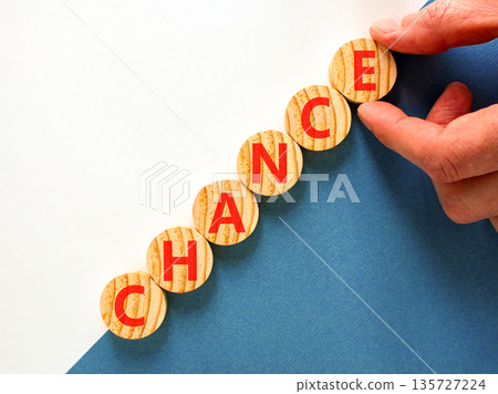 Chance symbol. Concept word Chance on beautiful wooden circles. Beautiful blue and white background. Businessman's hand. Business chance concept. Copy space. 135727224