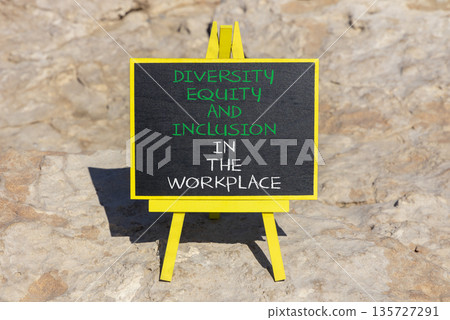 Diversity equity inclusion symbol. Concept words Diversity Equity and Inclusion in the workplace on blackboard on a beautiful stone background. Diversity equity inclusion workplace concept. Copy space Diversity equity inclusion symbol. Concept words Diversity Equity and Inclusion in the workplace on blackboard on a beautiful stone background. Diversity equity inclusion workplace concept. Copy space 135727291