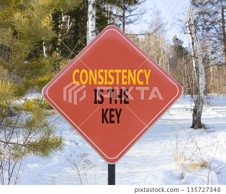 Consistency is the key symbol. Concept words Consistency is the key on beautiful red road sign. Beautiful winter forest background. Business consistency is the key concept. Copy space. 135727348