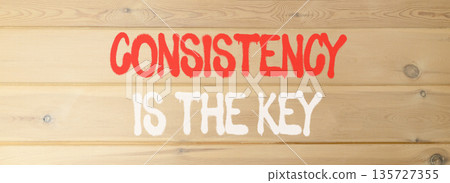 Consistency is the key symbol. Concept words Consistency is the key on beautiful wooden wall. Beautiful wooden wall background. Business consistency is the key concept. Copy space. 135727355