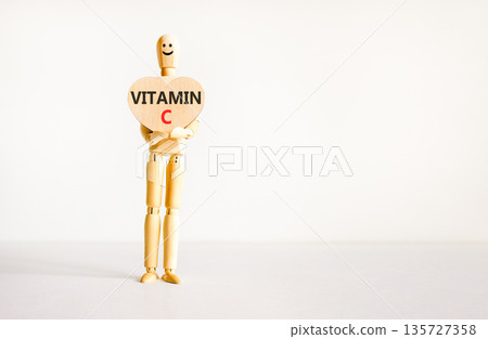 Vitamin C symbol. Concept words Vitamin C on beautiful wooden heart. Doctor's model. Beautiful white background. Copy space. Medical healthy lifestyle Vitamin C concept. Vitamin C symbol. Concept words Vitamin C on beautiful wooden heart. Doctor's model. Beautiful white background. Copy space. Medical healthy lifestyle Vitamin C concept. 135727358