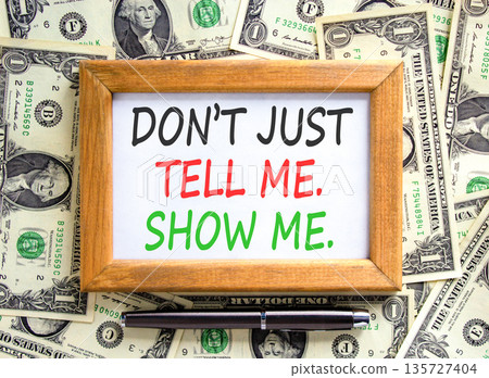 Tell or show symbol. Concept words Do not just tell me, show me on beautiful wooden picture frame. Beautiful dollar bills background. Business tell or show concept. Copy space. Tell or show symbol. Concept words Do not just tell me, show me on beautiful wooden picture frame. Beautiful dollar bills background. Business tell or show concept. Copy space. 135727404