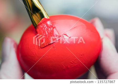 Chicken egg paint with a brush in red Chicken egg paint with a brush in red 135727867