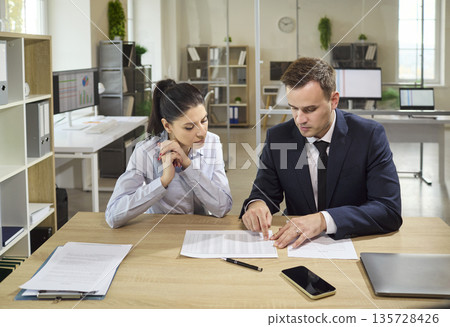 Bank advisor reviewing loan documents with client and explaining contract terms Bank advisor reviewing loan documents with client and explaining contract terms 135728426