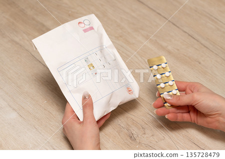 Woman's hand holding a bag with medicines Woman's hand holding a bag with medicines 135728479