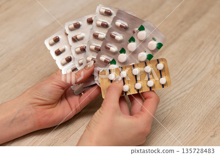 Woman's hand holding a lot of medicine Woman's hand holding a lot of medicine 135728483