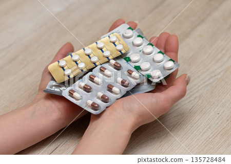 Woman's hand holding a lot of medicine Woman's hand holding a lot of medicine 135728484