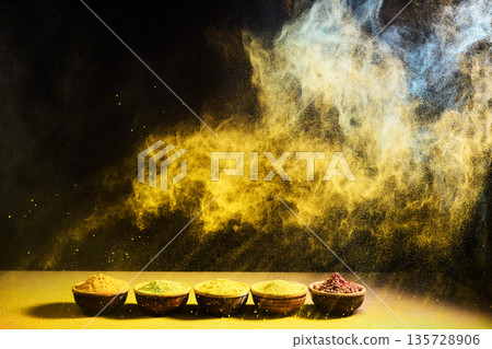 Colorful spice powder exploding over bowls with aroma Colorful spice powder exploding over bowls with aroma 135728906