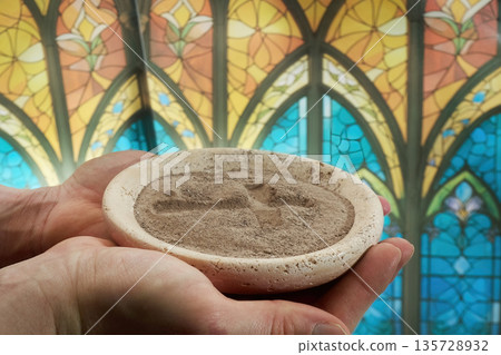 Hands holding ash wednesday ashes ritual in church Hands holding ash wednesday ashes ritual in church 135728932