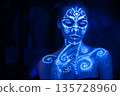 Body art on the body and hand of a girl glowing in the ultraviolet light. 135728960
