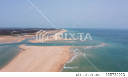 Drone captures a wide view of Ria Formosa and Praia de Faro in Portugal, showing sand, water, and natural beauty under clear skies during the day Drone captures a wide view of Ria Formosa and Praia de Faro in Portugal, showing sand, water, and natural beauty under clear skies during the day 135729023