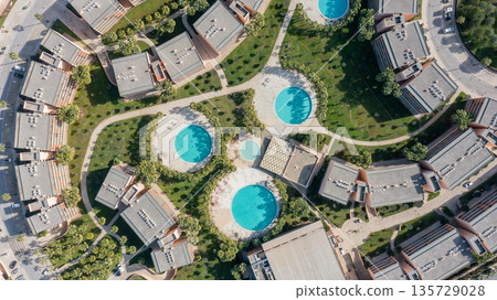 Aerial view of a residential area in Albufeira, Algarve, Portugal. The scene includes several swimming pools surrounded by green spaces and buildings Aerial view of a residential area in Albufeira, Algarve, Portugal. The scene includes several swimming pools surrounded by green spaces and buildings 135729028