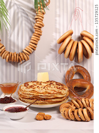 Delicious Russian pancakes with soft cheese, honey, jam, sour cream and bagels, pretzels on an elegant festive table.The Maslenitsa concept and traditional Russian cuisine.Advertising banner for cafe 135729125