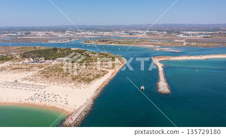 Aerial view of sandy beach with turquoise waters, boats navigating through channels, showcasing natural beauty and coastal serenity. Tavira Portugal Algarve 135729180