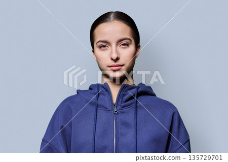 Beautiful young woman in casual wear looking at camera on grey background Beautiful young woman in casual wear looking at camera on grey background 135729701