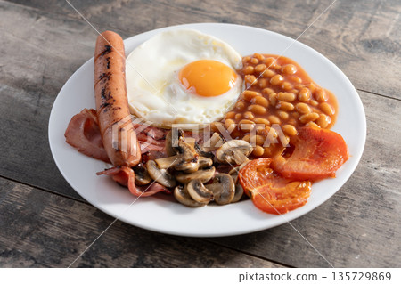Full English breakfast with fried egg, bacon, sausages and beans Full English breakfast with fried egg, bacon, sausages and beans 135729869