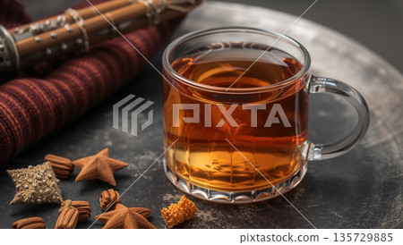 Warm Beverage in a Glass Cup With Spices on a Table in a Cozy Setting Warm Beverage in a Glass Cup With Spices on a Table in a Cozy Setting 135729885