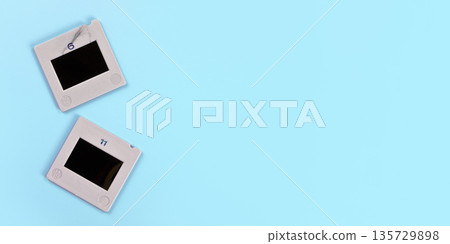 Two diapositive photo slides on light blue table, view from above, space for text right side - retro photography concept 135729898