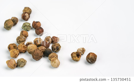 Dry green peppercorns isolated on white background board, closeup view Dry green peppercorns isolated on white background board, closeup view 135730451