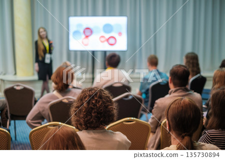Business conference presentation with speaker addressing audience in a formal meeting room Business conference presentation with speaker addressing audience in a formal meeting room 135730894