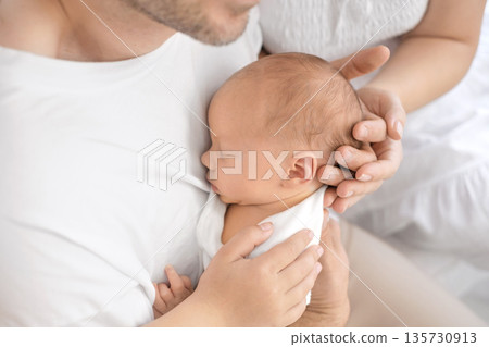 The father gently holds the newborn in his arms, hugging him tightly. Caring and love for children The father gently holds the newborn in his arms, hugging him tightly. Caring and love for children 135730913