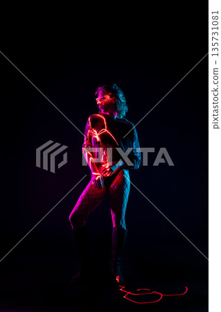 Cyberpunk woman in futuristic glowing glasses posing with neon light trails Cyberpunk woman in futuristic glowing glasses posing with neon light trails 135731081