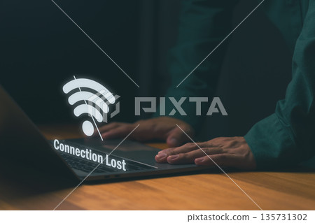 Close-up of person using laptop with Wi-Fi icon and Connection Lost, symbolizing internet disconnection or network failure. Concept for online issues, connectivity problems, or system downtime. 135731302