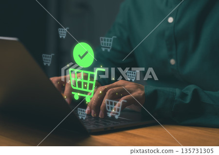 Person using laptop for online shopping with glowing cart icons, representing e-commerce, digital payment, and internet retail. Concept of secure online transaction and modern consumer behavior. Person using laptop for online shopping with glowing cart icons, representing e-commerce, digital payment, and internet retail. Concept of secure online transaction and modern consumer behavior. 135731305