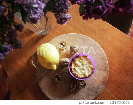 A home-baked tart with lemon and walnuts on a round wooden board. Candid, cozy scene is perfect for food and lifestyle content. Rustic food. 135731601